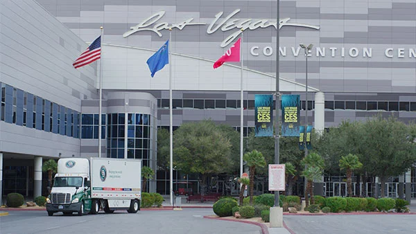 A truck parked outside the Las Vegas Convention Center, delivering shipments for a trade show event.