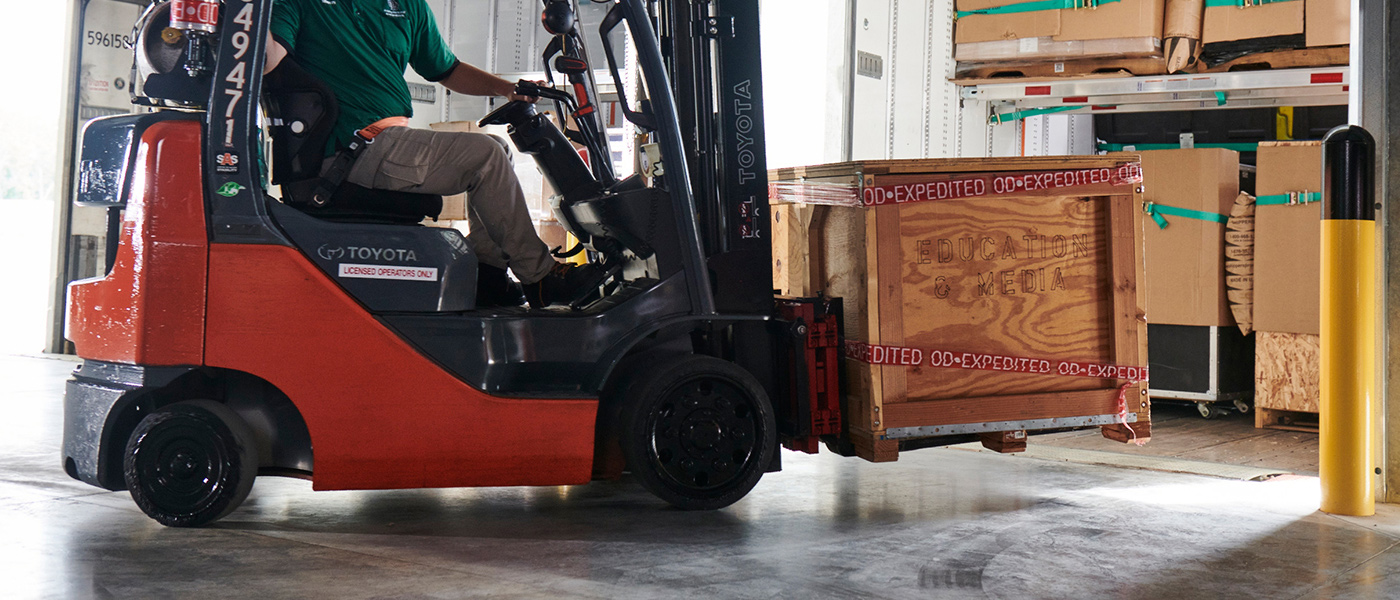 Forklift moving freight labeled "OD-Expedited," representing LTL guaranteed delivery service.