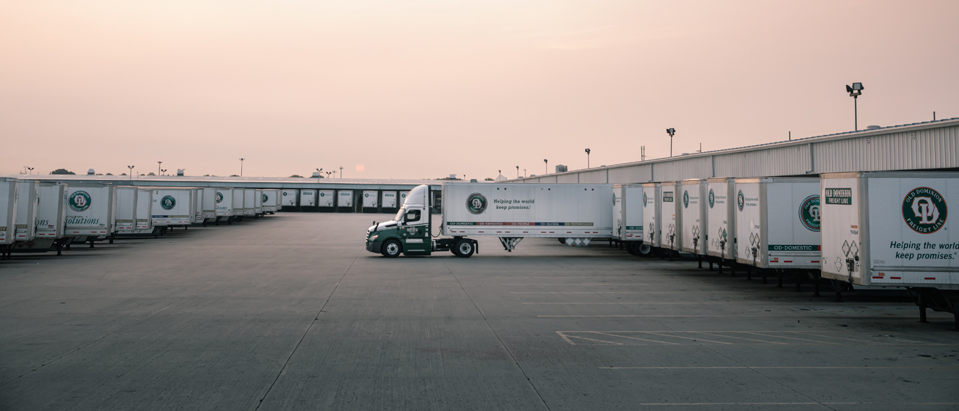 A fleet of Old Dominion Freight Line trucks parked at a distribution center, highlighting specialized delivery services.