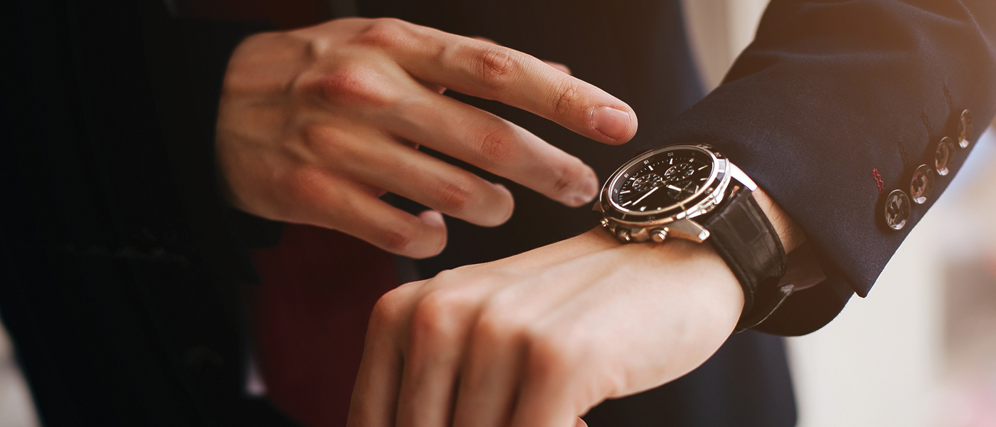 Close-up of a person checking their watch, symbolizing the precision of on demand delivery.