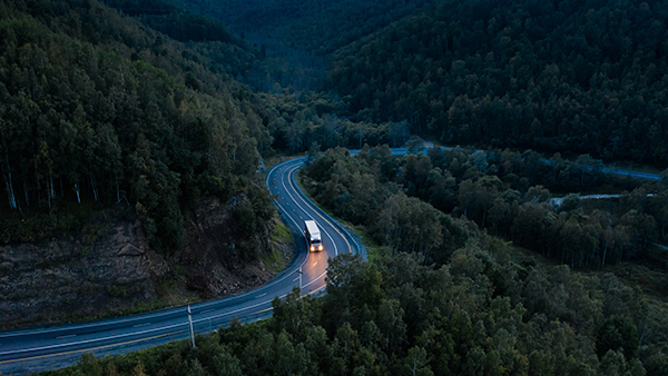 Truck on a winding road at dusk, representing next day shipping to Canada.
